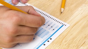 Student filling out answers to a test with a pencil.